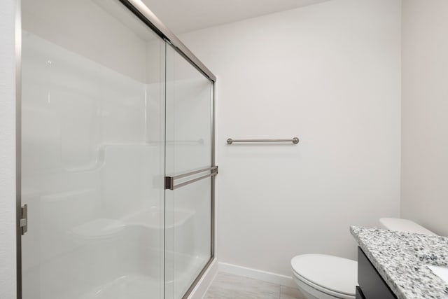 bathroom featuring vanity, toilet, and an enclosed shower