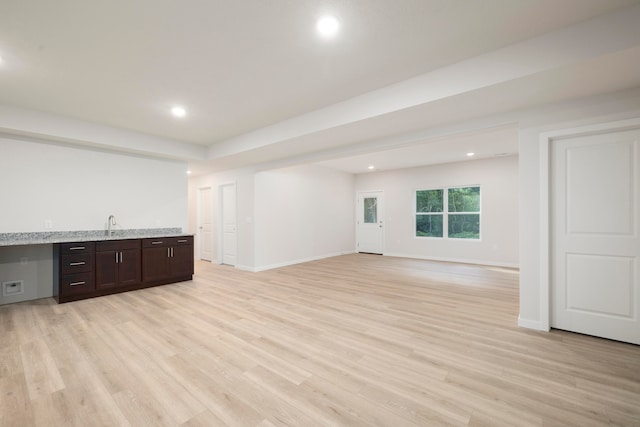 interior space with light wood-type flooring, built in desk, and sink