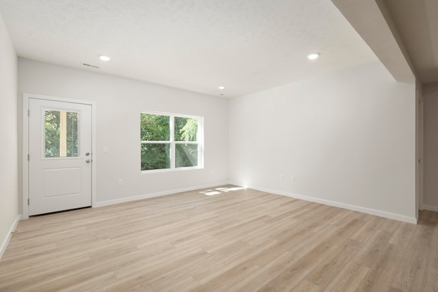 interior space with light wood-type flooring and a textured ceiling