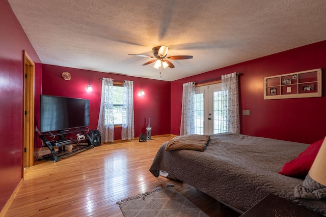 bedroom featuring ceiling fan, access to exterior, a textured ceiling, and hardwood / wood-style floors