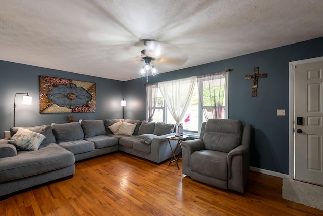 living room with ceiling fan, hardwood / wood-style floors, and a textured ceiling