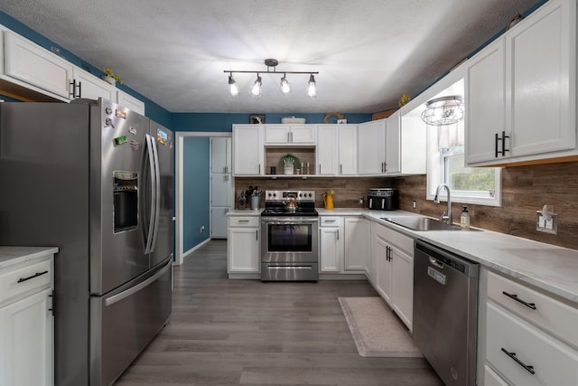 kitchen with white cabinets, appliances with stainless steel finishes, backsplash, and sink