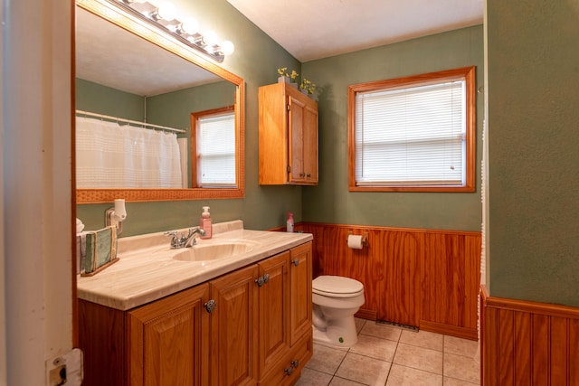 bathroom featuring vanity, plenty of natural light, toilet, and tile patterned flooring