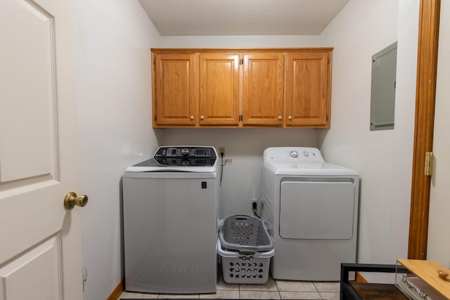 laundry room with light tile patterned flooring, electric panel, cabinets, independent washer and dryer, and a textured ceiling