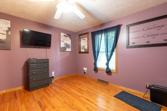 interior space with hardwood / wood-style flooring, ceiling fan, and a textured ceiling