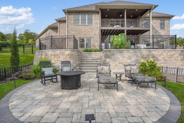 view of patio / terrace featuring a balcony and an outdoor fire pit