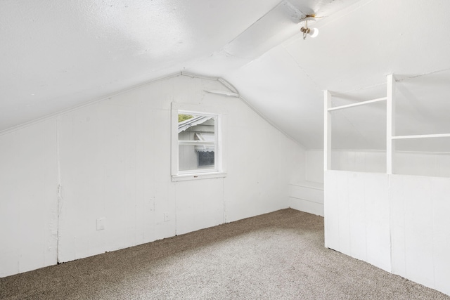 bonus room featuring carpet floors, vaulted ceiling, and a textured ceiling