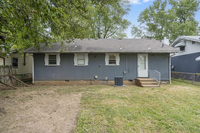 back of property featuring central AC unit and a lawn