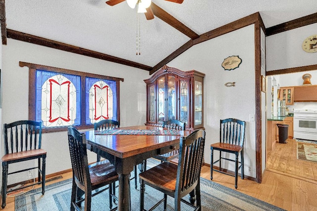 dining room featuring a textured ceiling, light hardwood / wood-style floors, ceiling fan, and lofted ceiling