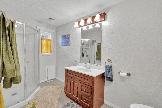 bathroom featuring vanity, an enclosed shower, and a textured ceiling