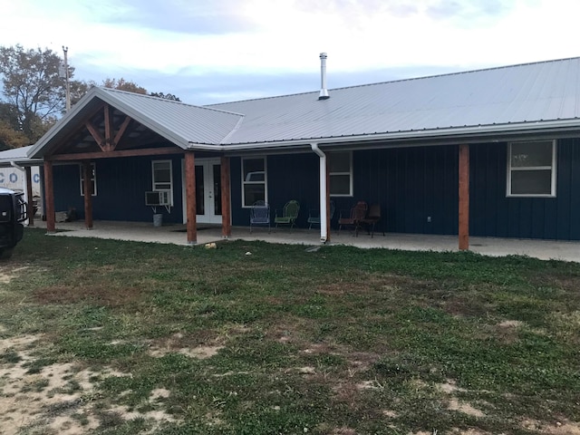 rear view of property with a lawn and a patio