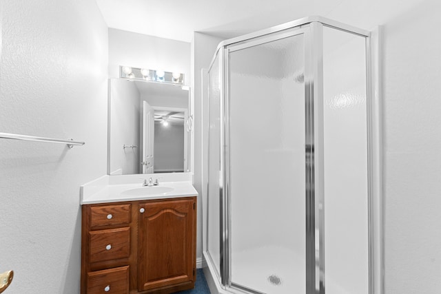 bathroom featuring a shower with door and vanity