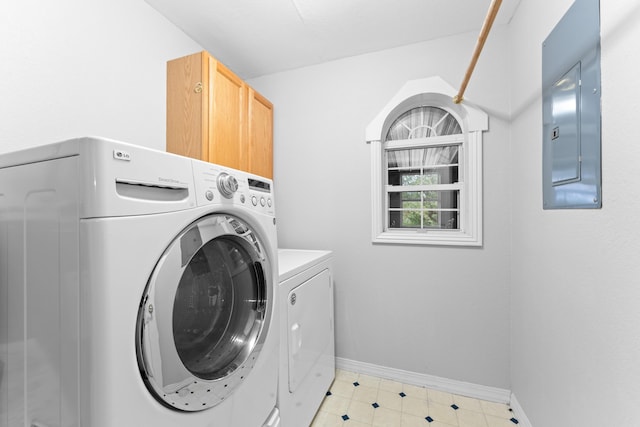 laundry area featuring electric panel, baseboards, washer and clothes dryer, and cabinet space