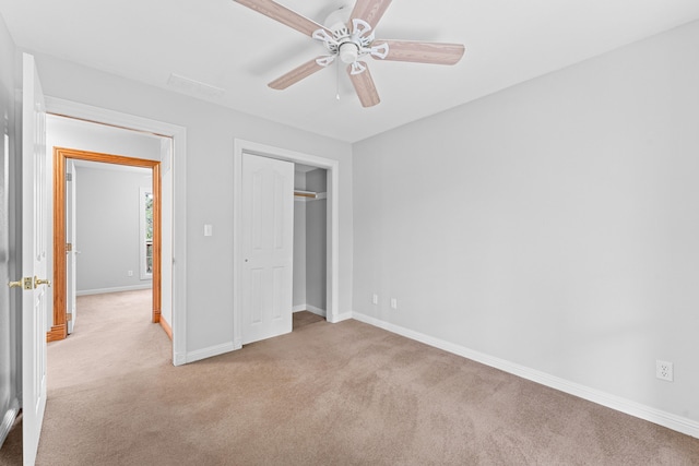 unfurnished bedroom featuring light carpet, ceiling fan, and a closet