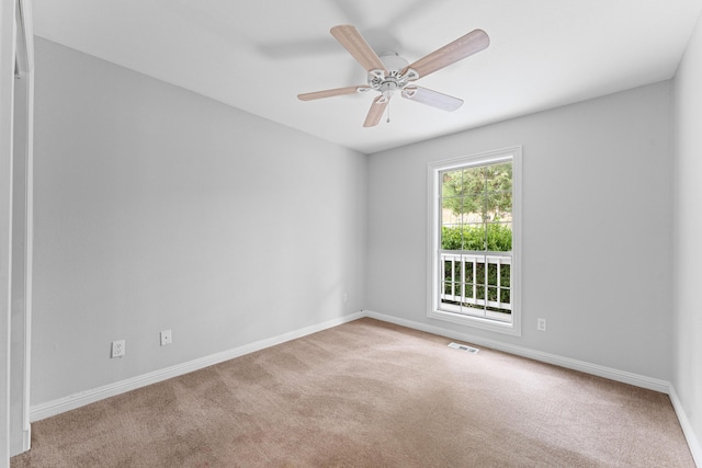 empty room featuring baseboards, a ceiling fan, visible vents, and carpet