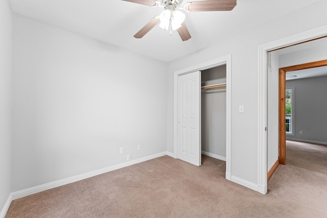 unfurnished bedroom with ceiling fan, a closet, and light colored carpet