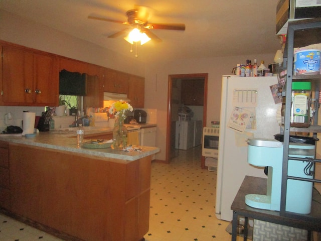 kitchen with ceiling fan, kitchen peninsula, ventilation hood, and white refrigerator