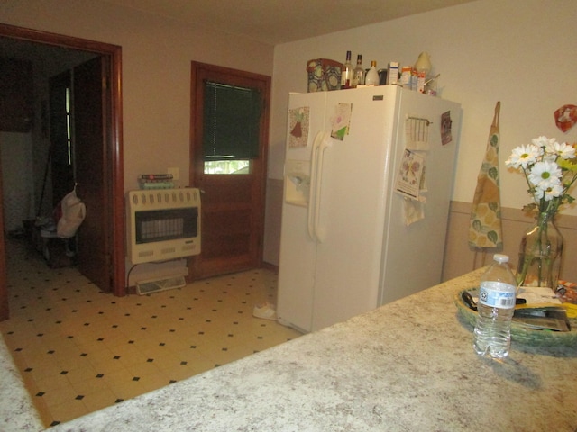 kitchen featuring heating unit and white fridge