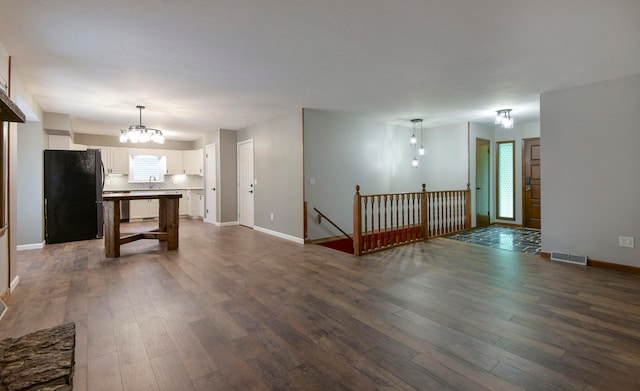 spare room featuring dark hardwood / wood-style floors and a chandelier