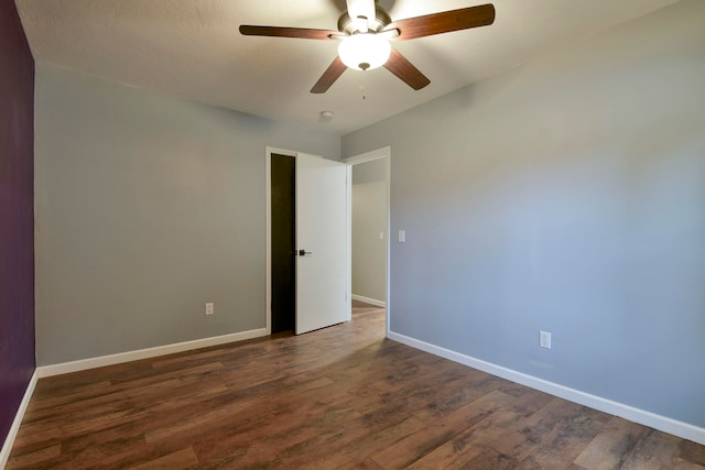 empty room with ceiling fan and dark wood-type flooring