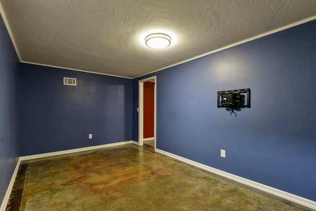 spare room featuring concrete floors, ornamental molding, and a textured ceiling