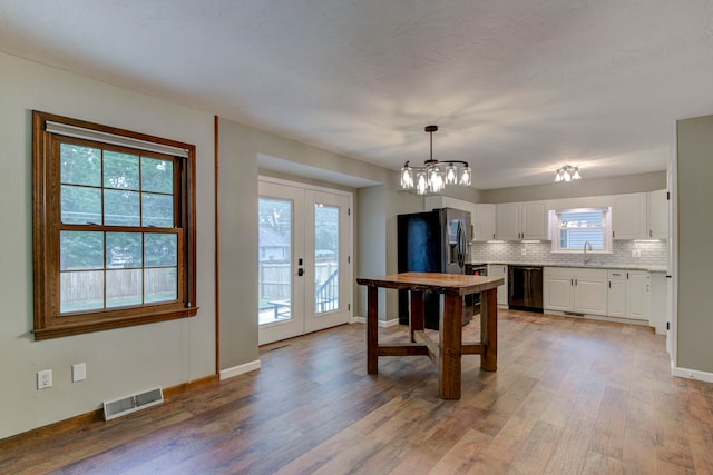 kitchen featuring white cabinets, hanging light fixtures, and a healthy amount of sunlight