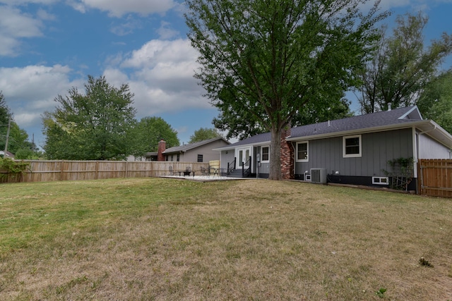 rear view of house with a lawn, a patio area, and central AC