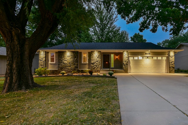 ranch-style house featuring a front yard and a garage