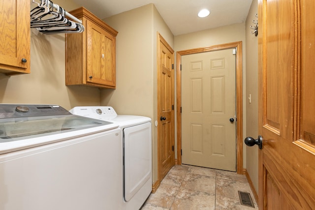 washroom featuring washer and clothes dryer and cabinets