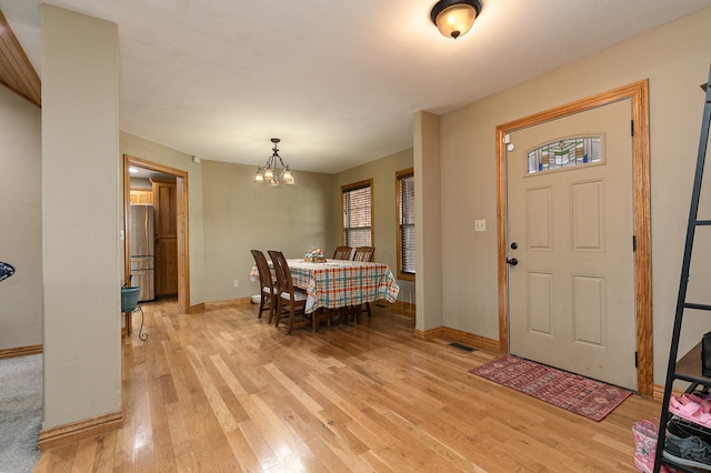 foyer with a chandelier and light hardwood / wood-style flooring