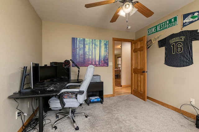 carpeted home office featuring a textured ceiling and ceiling fan