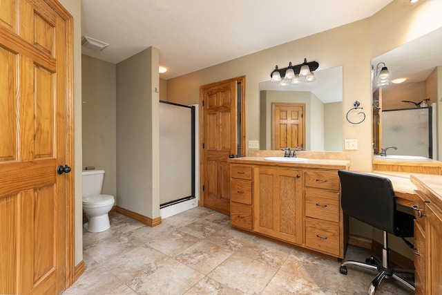 bathroom featuring a shower with door, vanity, and toilet