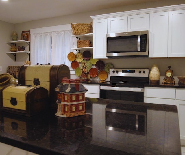 kitchen with open shelves, stainless steel appliances, white cabinetry, and dark countertops