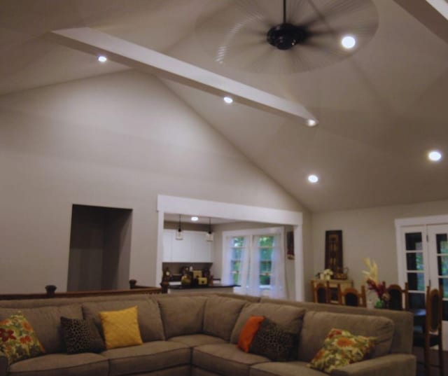 living room featuring ceiling fan, high vaulted ceiling, and beam ceiling