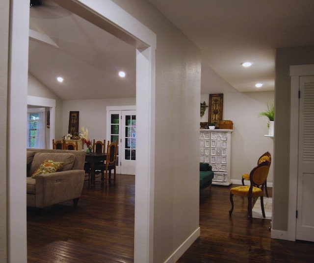 hall featuring baseboards, lofted ceiling, dark wood-style floors, and recessed lighting