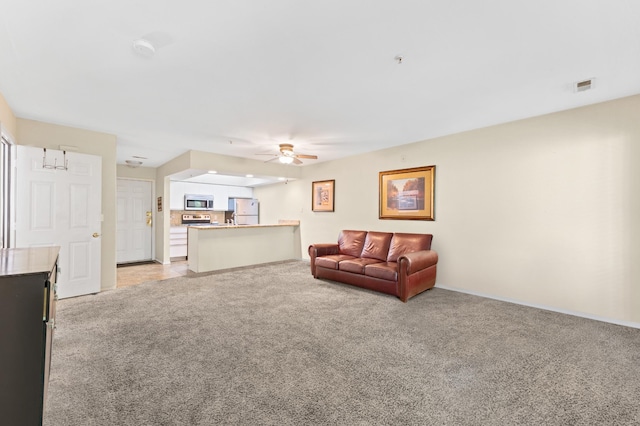 carpeted living room with ceiling fan