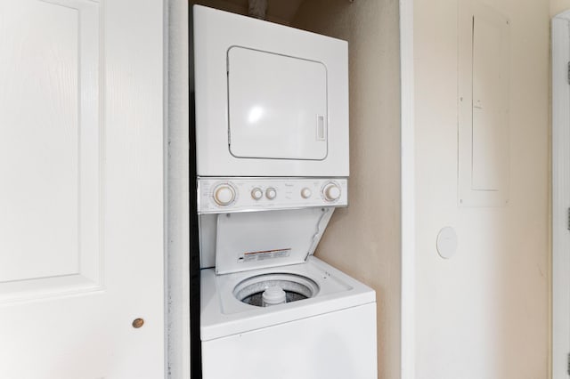 clothes washing area featuring stacked washing maching and dryer