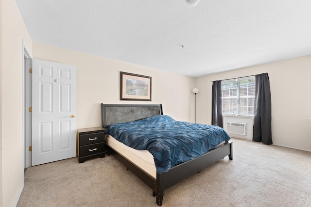 bedroom with light carpet, cooling unit, and a textured ceiling