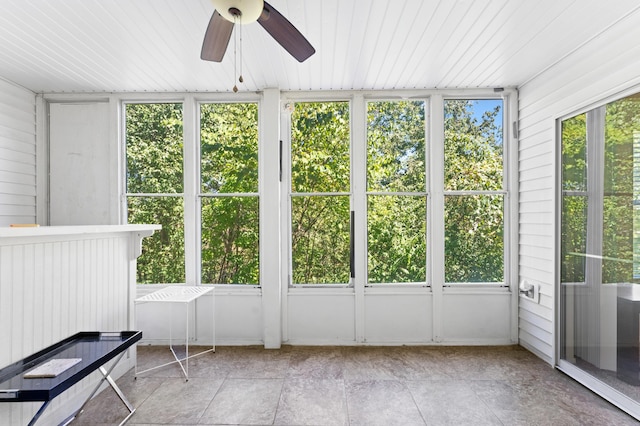 unfurnished sunroom with ceiling fan, wood ceiling, and plenty of natural light