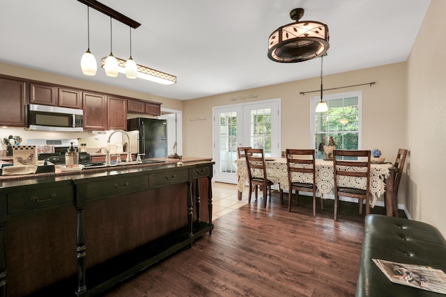 kitchen with pendant lighting, dark brown cabinetry, sink, dark hardwood / wood-style floors, and appliances with stainless steel finishes