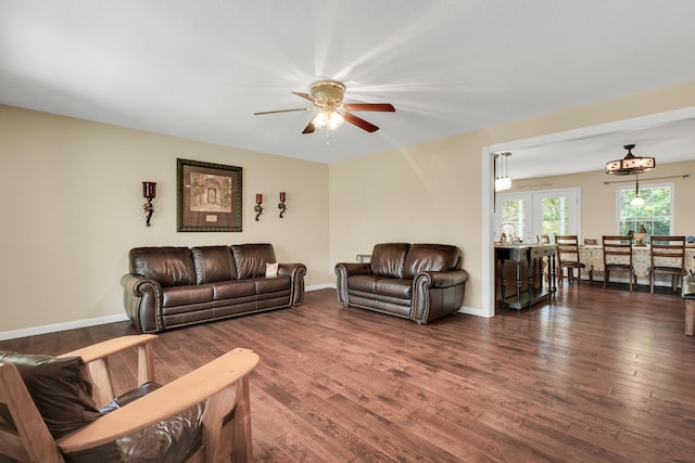 living room featuring ceiling fan and dark wood-type flooring