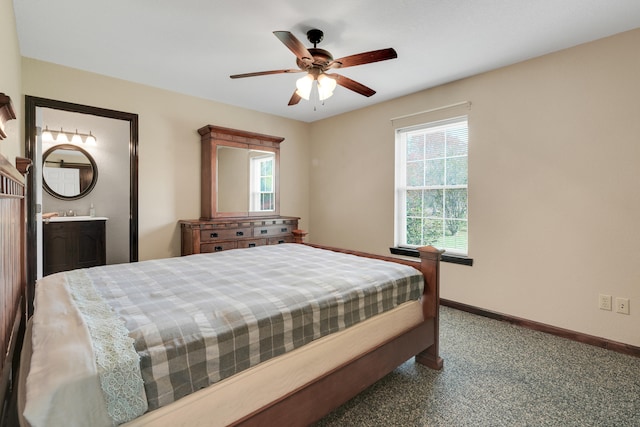 carpeted bedroom featuring ensuite bathroom, multiple windows, and ceiling fan