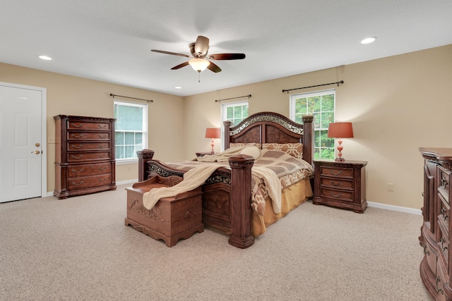 carpeted bedroom featuring multiple windows and ceiling fan