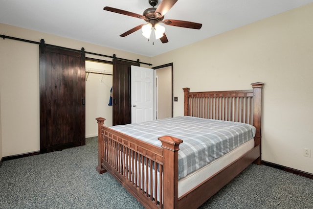 bedroom with ceiling fan, a closet, a barn door, and dark carpet