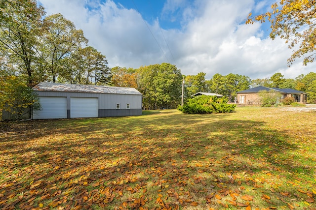 view of yard featuring a garage and an outdoor structure