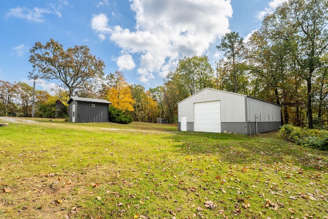 view of yard with a garage and an outbuilding