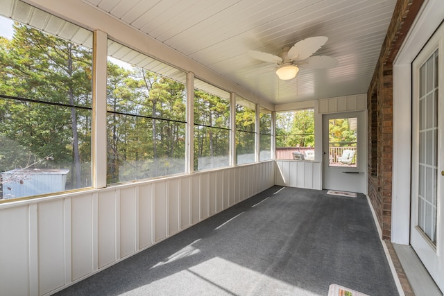 unfurnished sunroom with ceiling fan and plenty of natural light