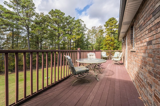 wooden deck featuring a lawn