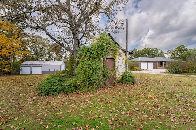 view of front facade featuring a garage, an outbuilding, and a front lawn