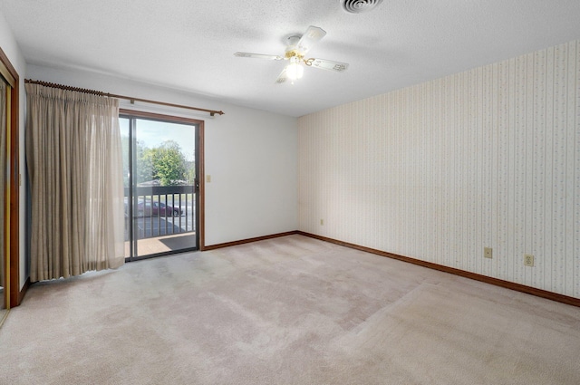 spare room with light carpet, a textured ceiling, and ceiling fan